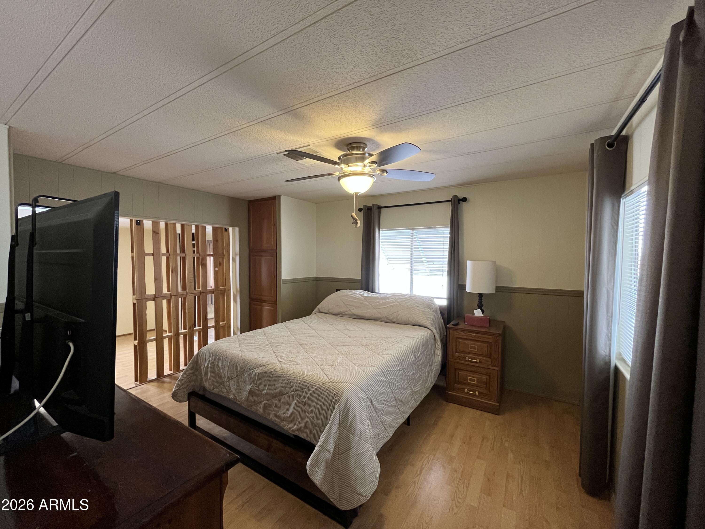 9302 East Broadway Road, Unit 179 Mesa, AZ 85208 - Photo 27 of 54 a bedroom with a bed and a flat tv screen