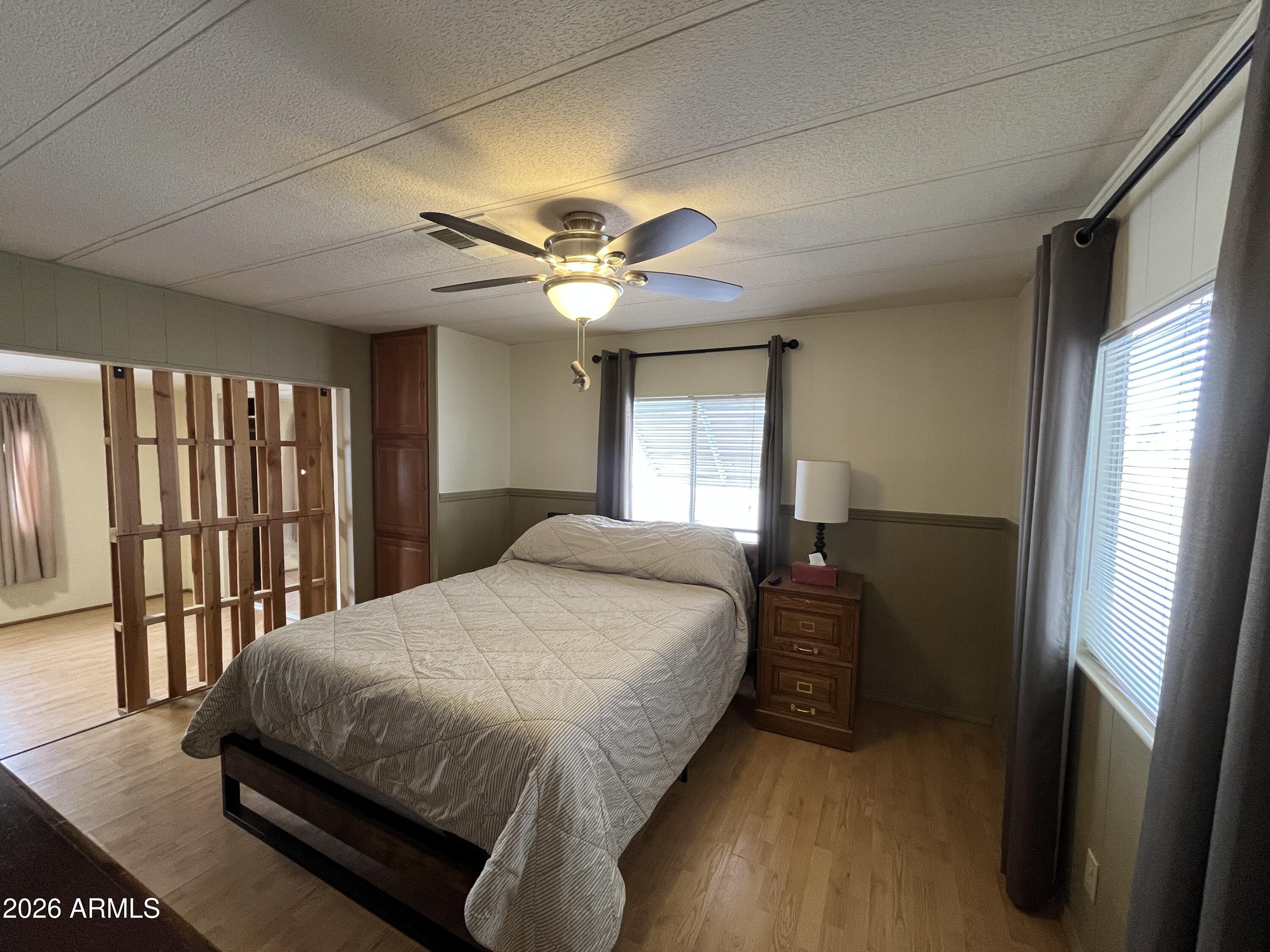 9302 East Broadway Road, Unit 179 Mesa, AZ 85208 - Photo 28 of 54 a bedroom with a large bed and a chandelier