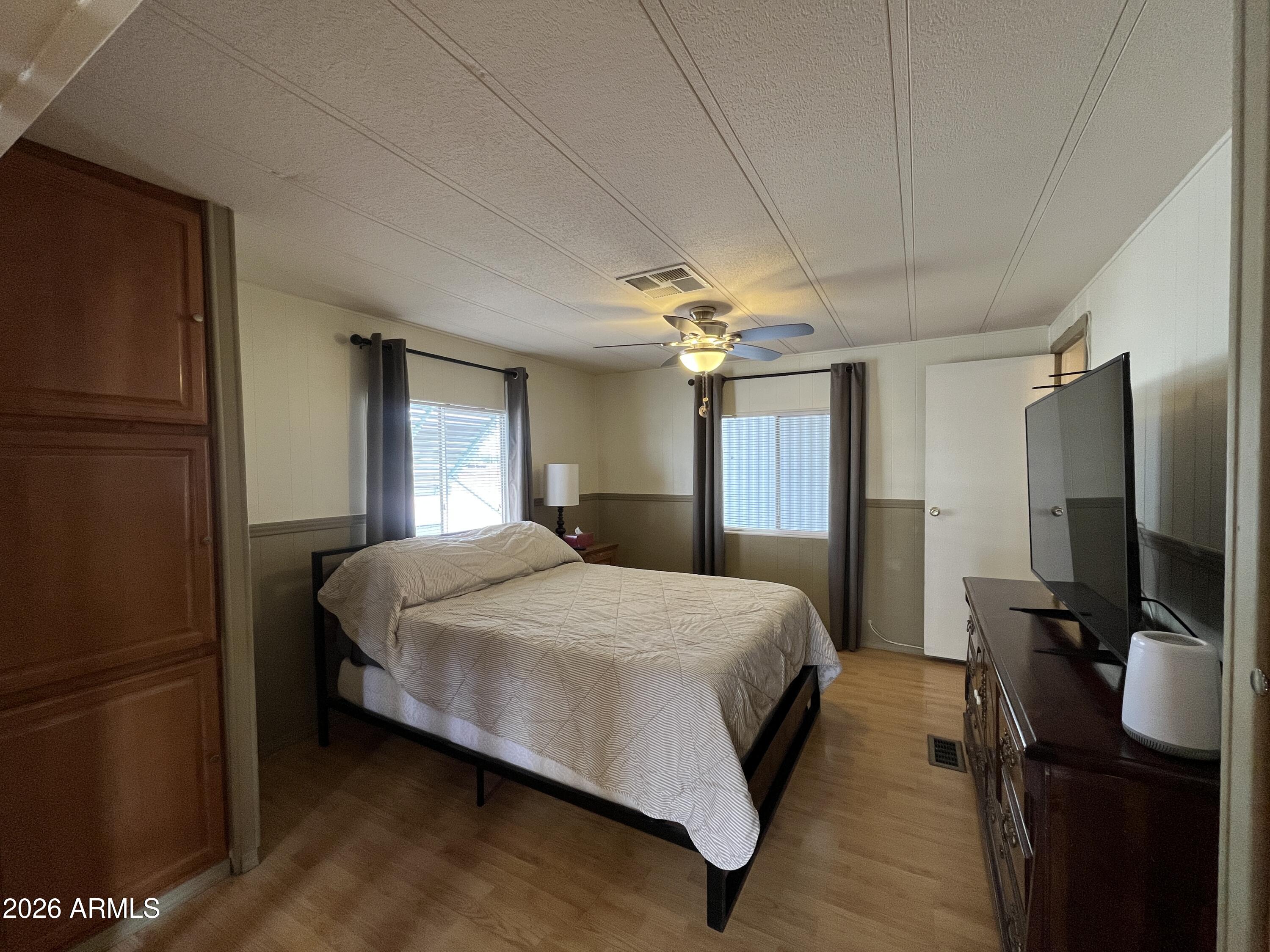 9302 East Broadway Road, Unit 179 Mesa, AZ 85208 - Photo 29 of 54 a bedroom with a bed tv and a large window