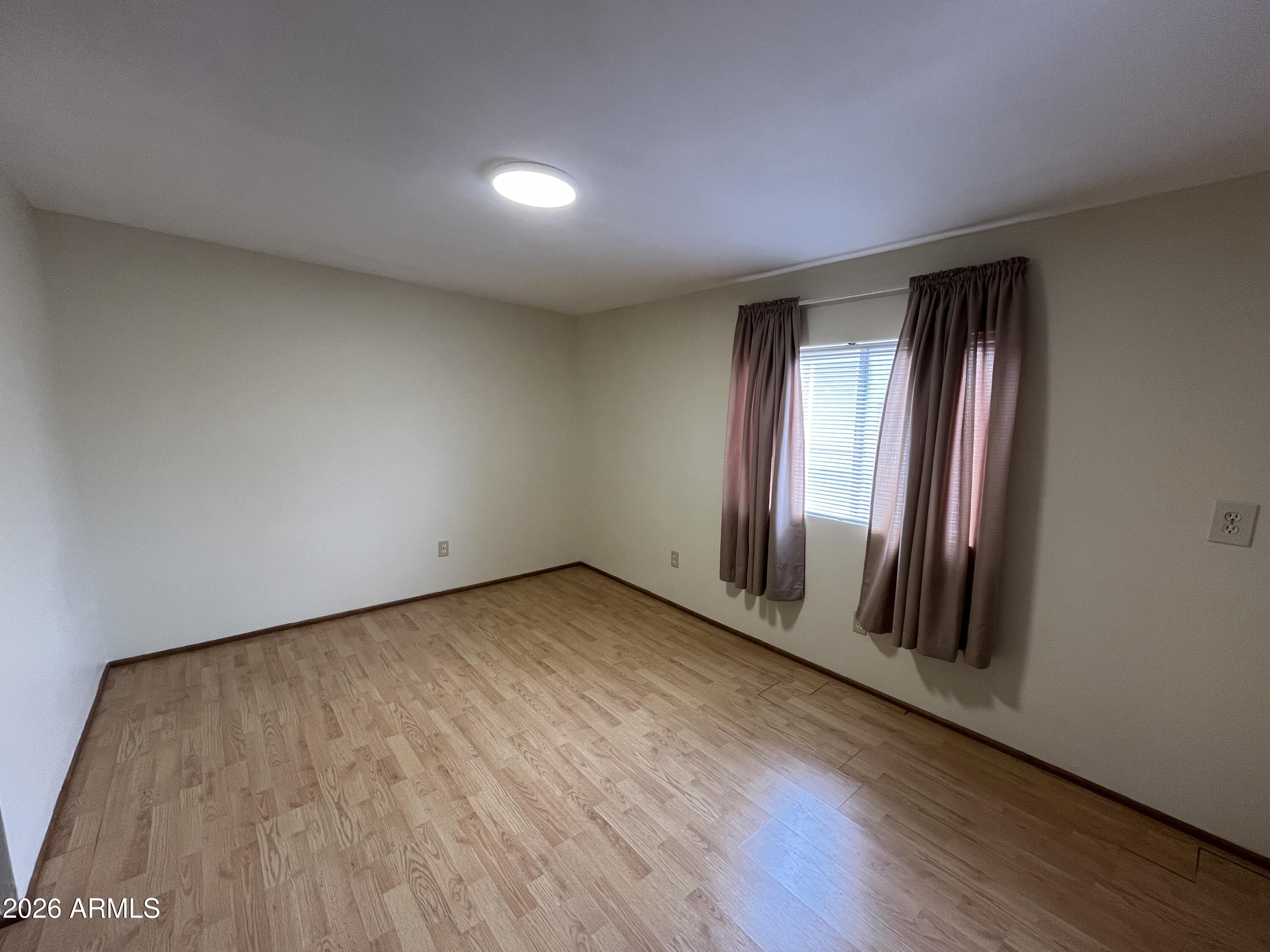 9302 East Broadway Road, Unit 179 Mesa, AZ 85208 - Photo 31 of 54 an empty room with wooden floor and windows