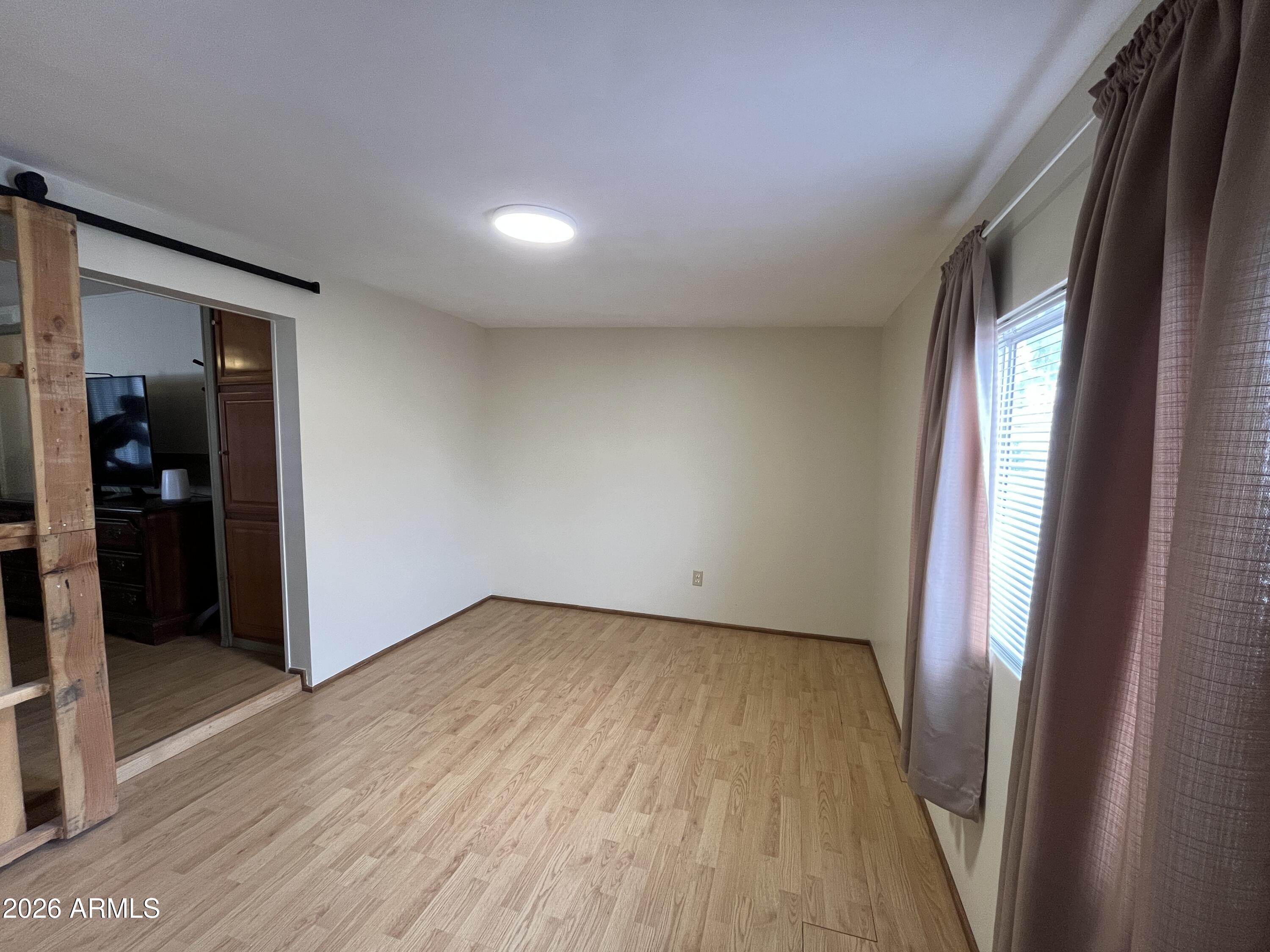 9302 East Broadway Road, Unit 179 Mesa, AZ 85208 - Photo 33 of 54 an empty room with wooden floor and entrance