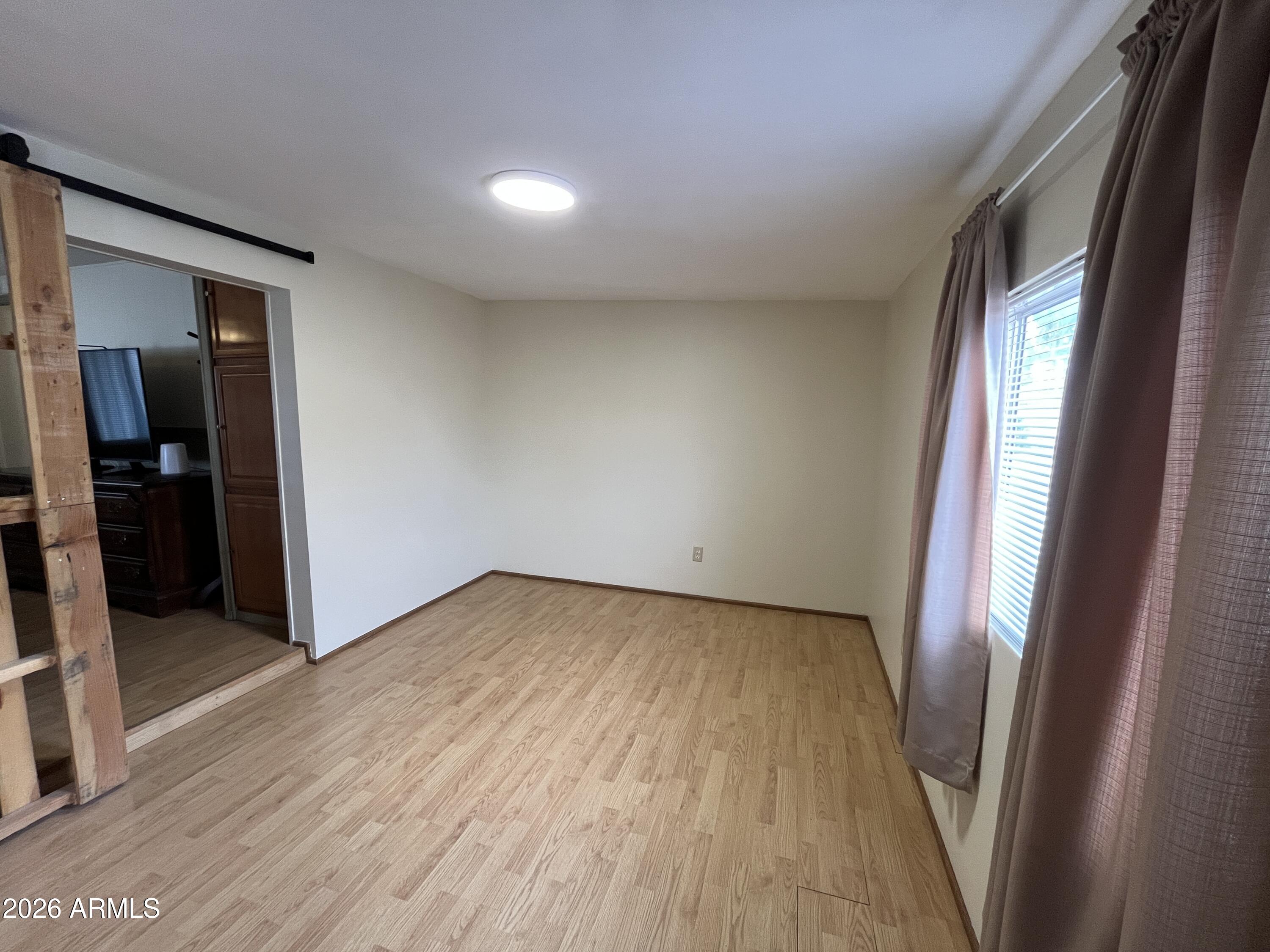 9302 East Broadway Road, Unit 179 Mesa, AZ 85208 - Photo 34 of 54 an empty room with wooden floor and sliding door