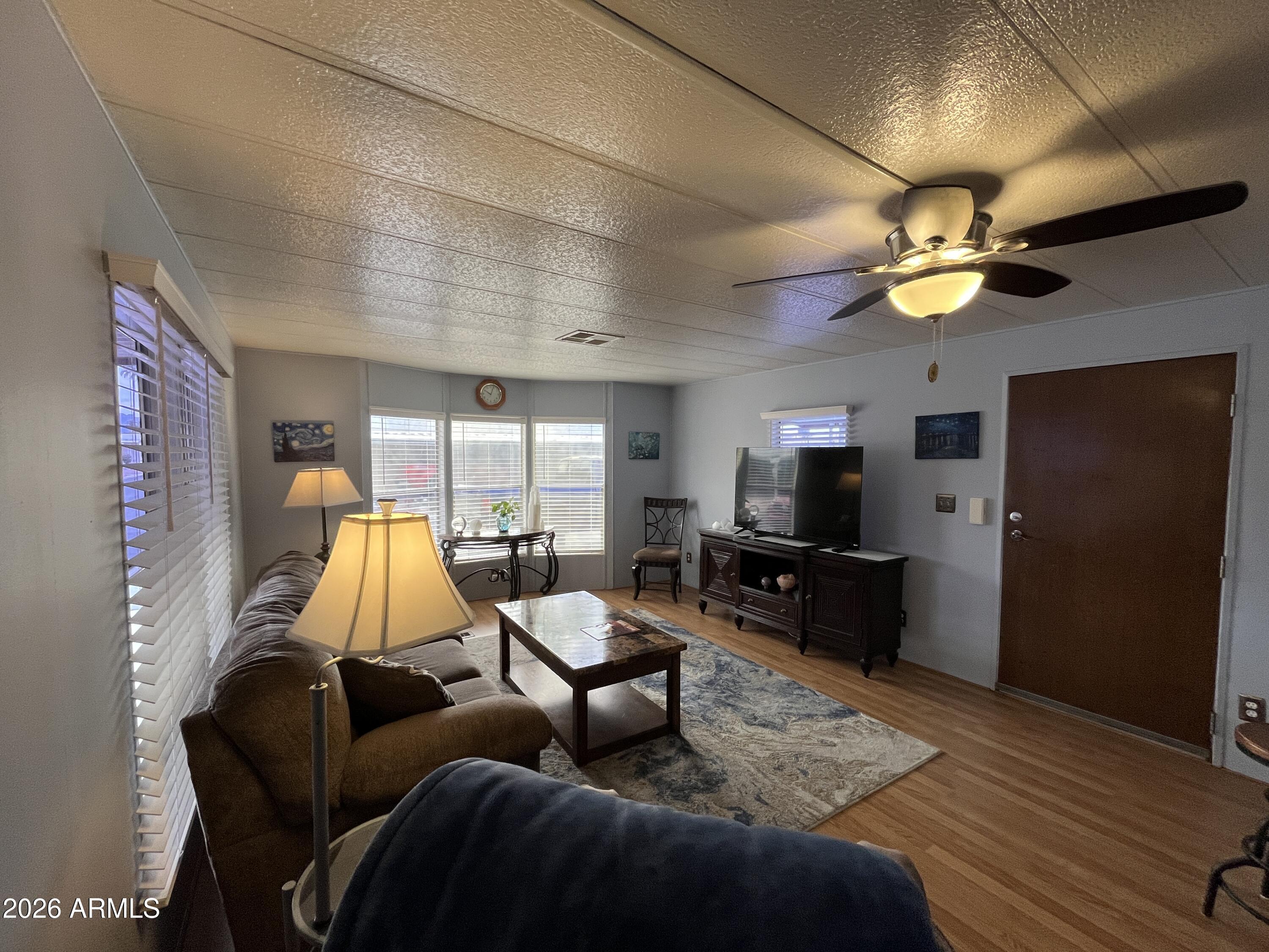 9302 East Broadway Road, Unit 179 Mesa, AZ 85208 - Photo 8 of 54 a living room with furniture and a flat screen tv