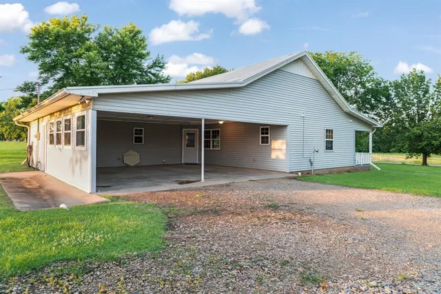 a view of a house with a yard and a large tree