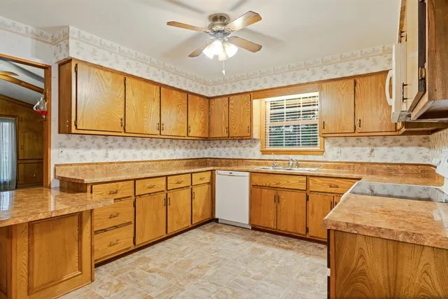 a kitchen with granite countertop a sink stove and cabinets