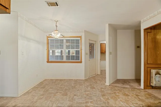 an empty room with windows and chandelier