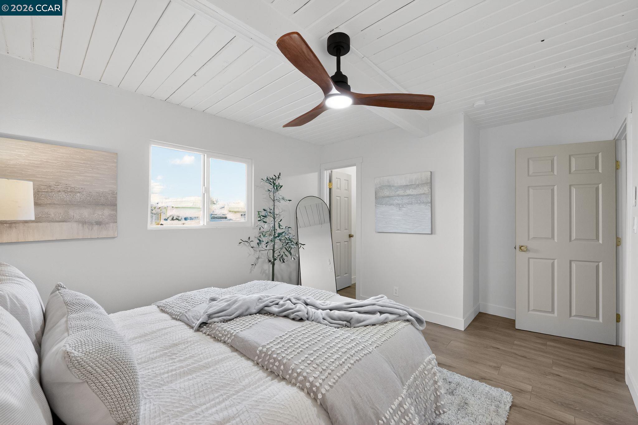 87 Bay Drive Bay Point, CA 94565 - Photo 15 of 22 a bedroom with a large bed chandelier and a window