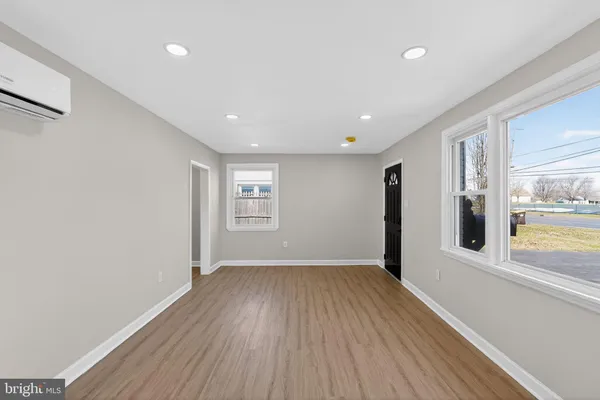 a view of a big room with wooden floor and windows