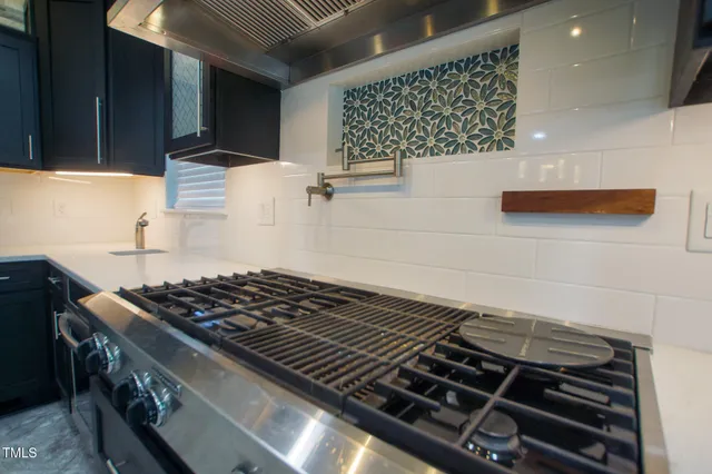 a stove sitting inside of a kitchen with white cabinets