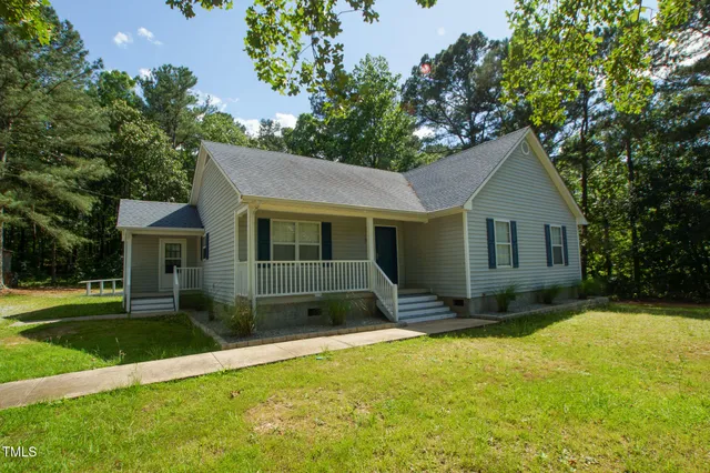 a view of a house with a yard and tree s