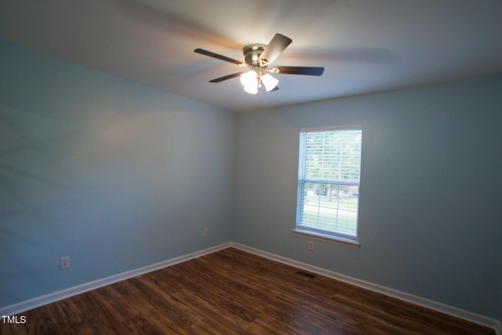 5705 Katha Drive Holly Springs, NC 27540 - Photo 23 of 27 a view of an empty room with wooden floor and a window