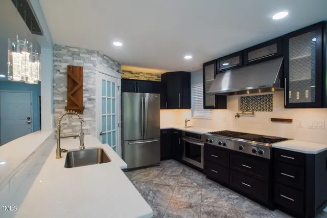 a kitchen with stainless steel appliances a sink and a refrigerator