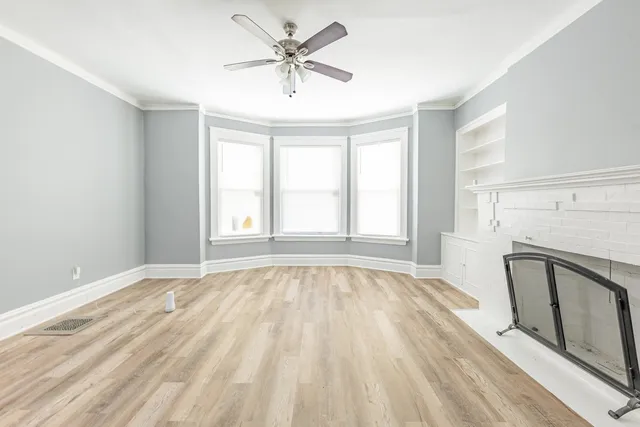 a view of an empty room with a fireplace and a window