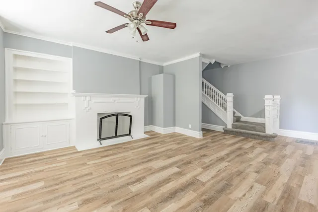 a view of a livingroom with wooden floor and a ceiling fan