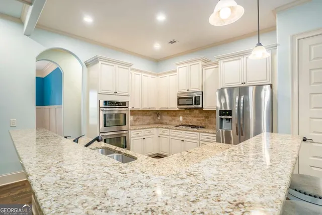 a kitchen with kitchen island granite countertop a stove cabinets and wooden floor