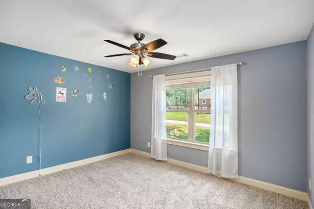 a view of an empty room with closet and a window