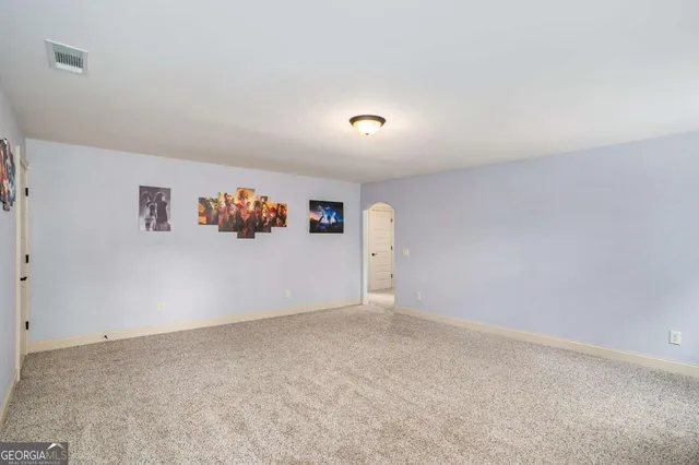 a swimming pool that has lawn chairs and a large tree
