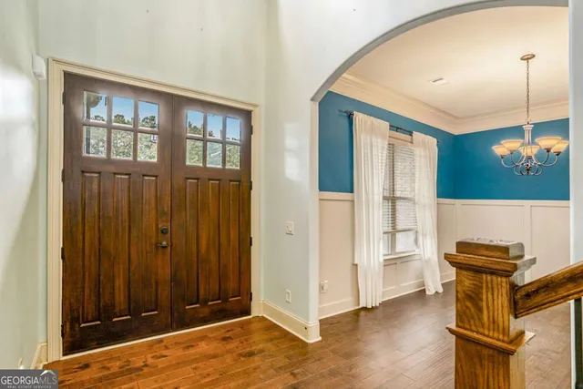 a view of a livingroom with wooden floor and kitchen space