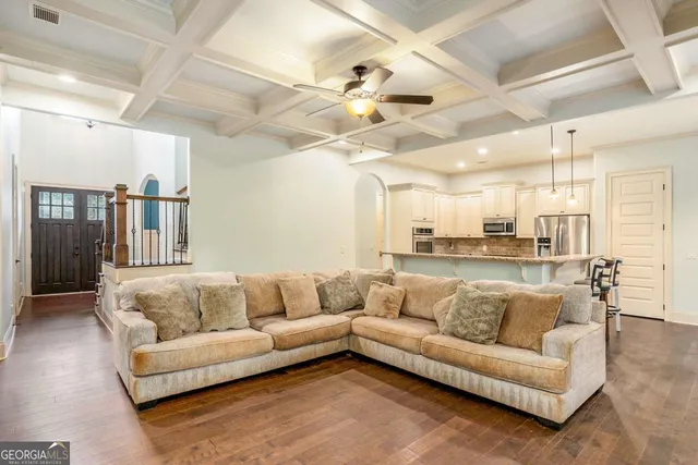a living room with furniture white walls and a chandelier