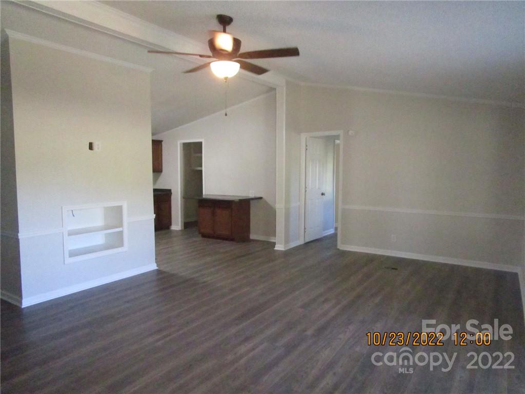 2605 Hinson Road, Unit P1 Monroe, NC 28112 - Photo 5 of 18 an empty room with wooden floor chandelier fan and windows