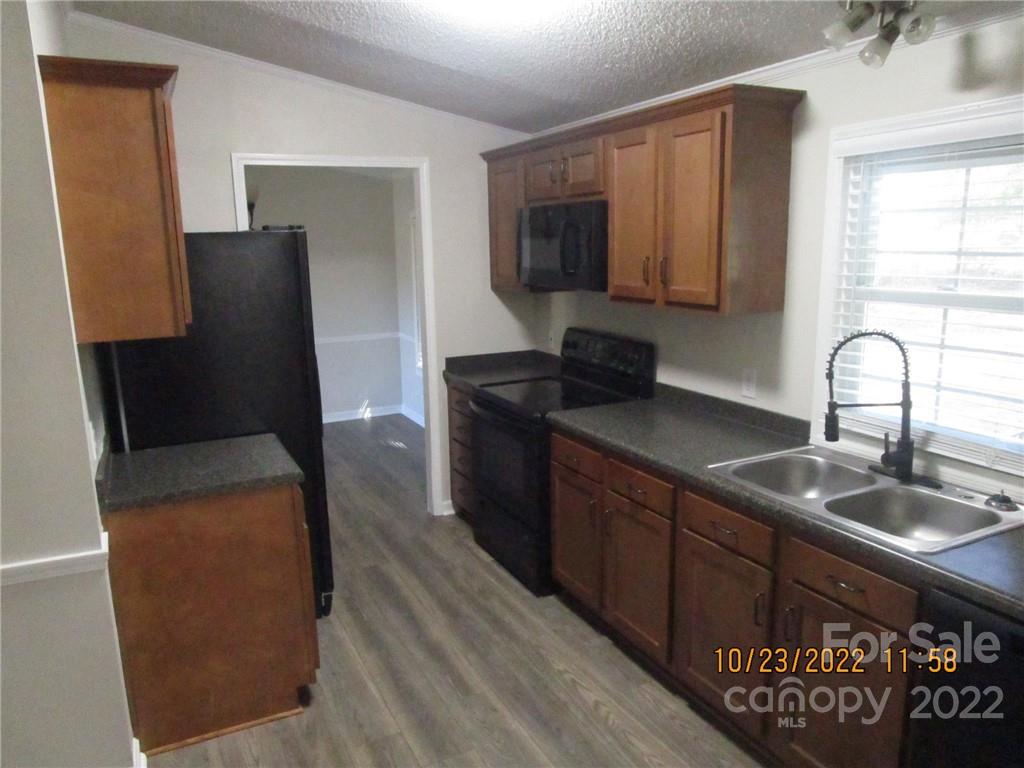 2605 Hinson Road, Unit P1 Monroe, NC 28112 - Photo 10 of 18 a kitchen with granite countertop a refrigerator a stove a sink and dishwasher with wooden floor