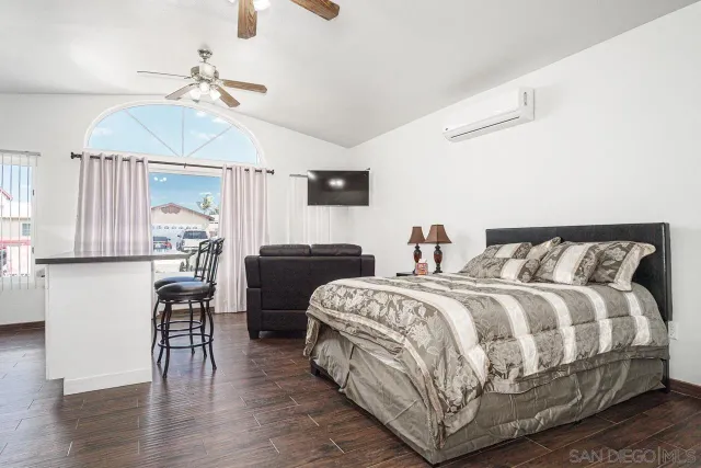 a bedroom with a bed and wooden floor