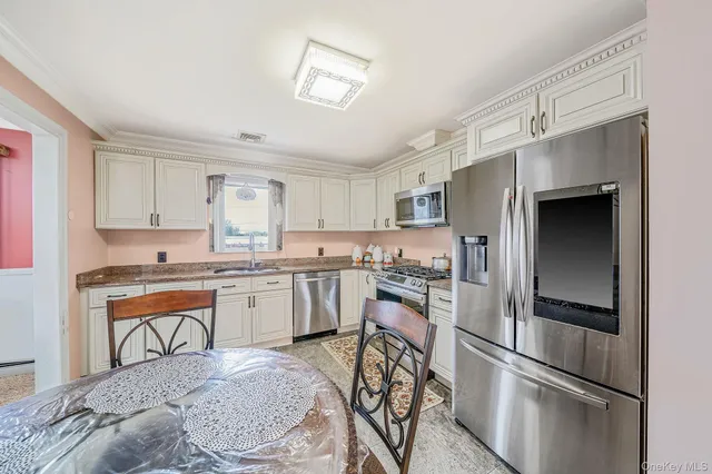 a kitchen with granite countertop a refrigerator stove and sink
