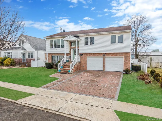 a front view of a house with a yard and trees