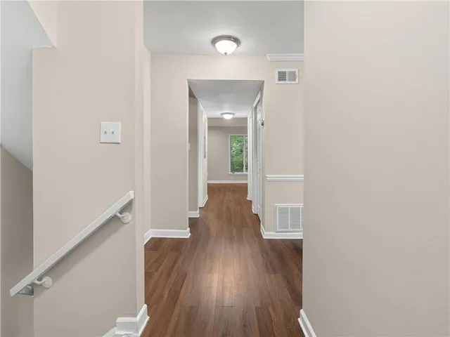 a view of an empty room with wooden floor