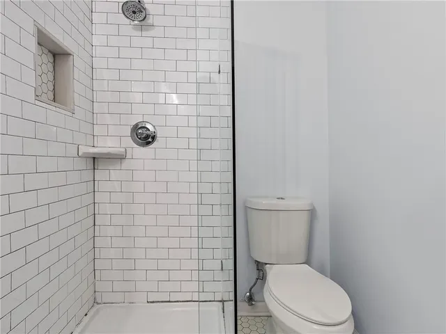a white toilet sitting next to a shower