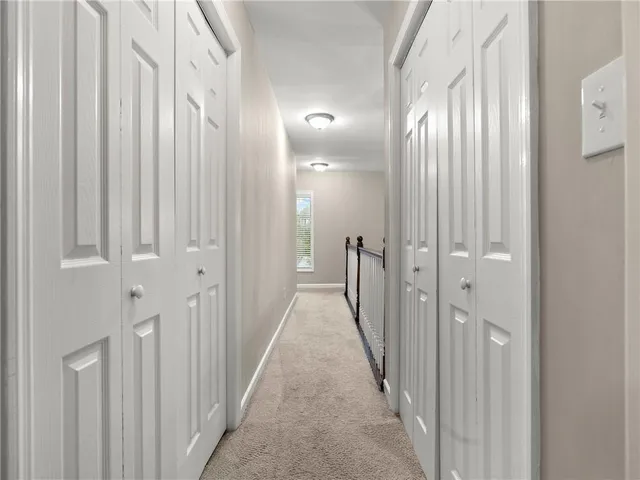 a view of a hallway with wooden floor and closet area