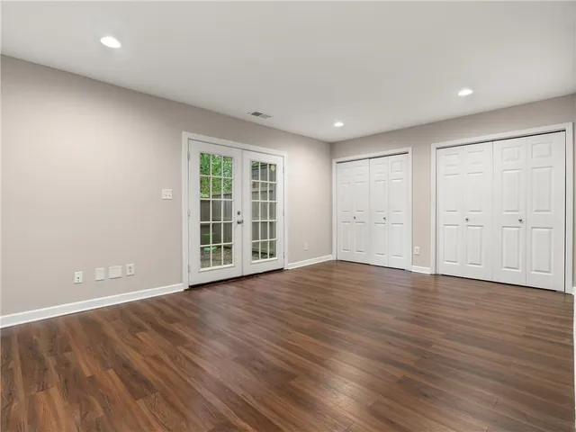 a view of empty room with wooden floor and windows