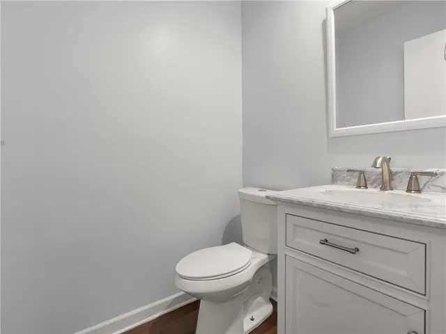 a bathroom with a granite countertop toilet and a sink
