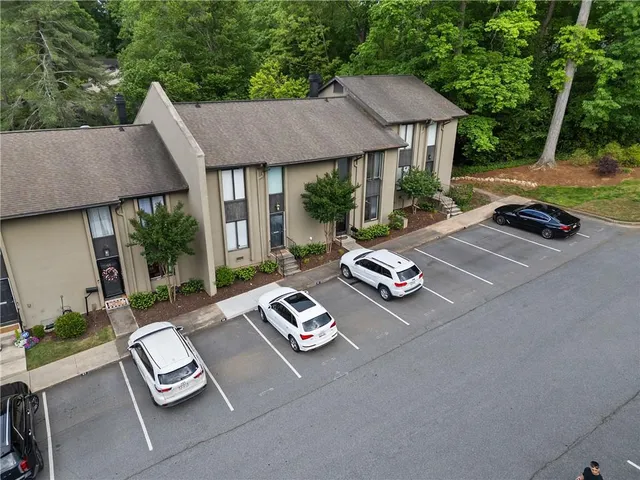 a view of a patio with table and chairs barbeque potted plants and large tree