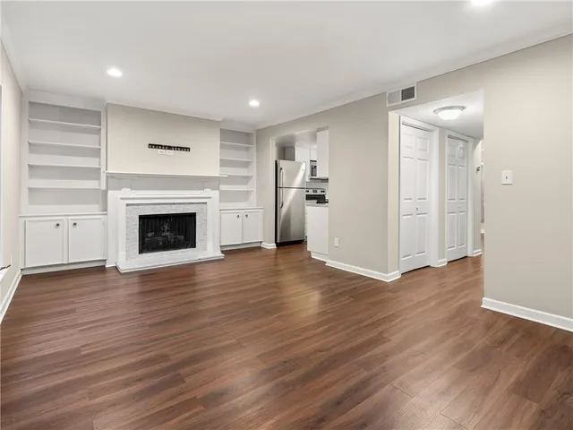 a view of a livingroom with wooden floor and a fireplace