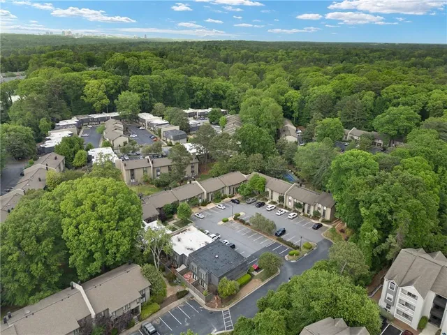 an aerial view of residential houses with outdoor space and trees