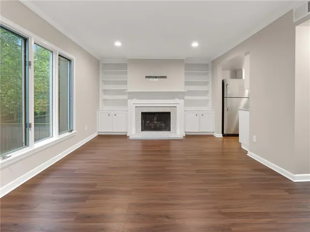 a view of empty room with wooden floor and fireplace