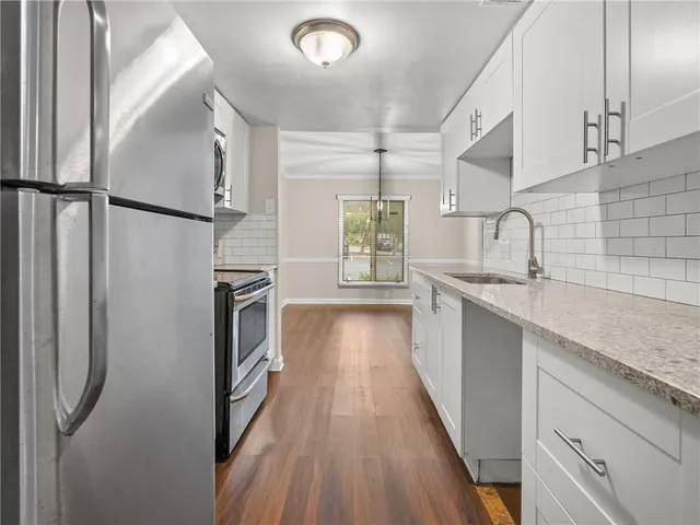 a kitchen with stainless steel appliances granite countertop a refrigerator and a sink