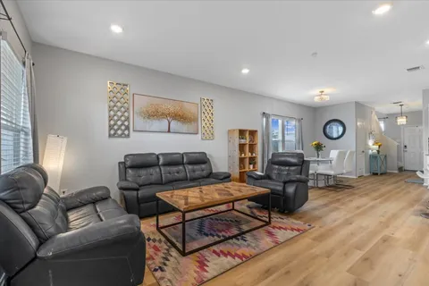 a living room with furniture and a wooden floor