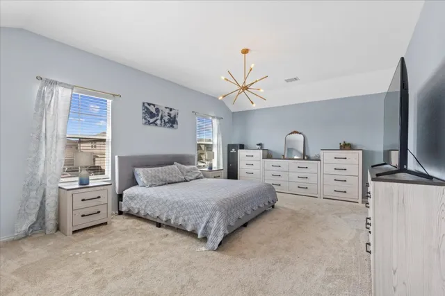 a bedroom with a bed and a flat tv screen on dresser