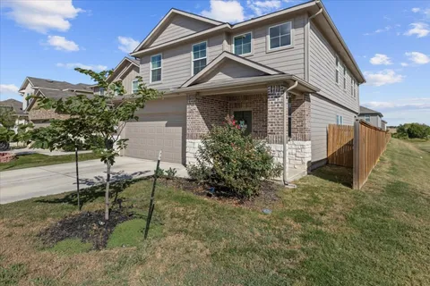 a view of a house with a yard and lawn chairs