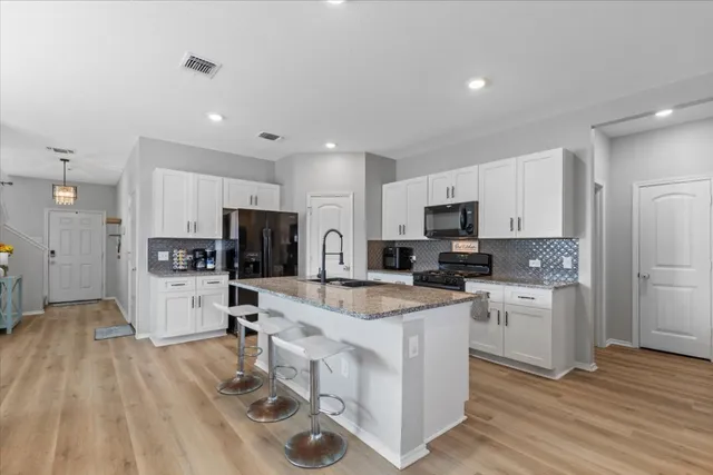 a kitchen with white cabinets and stainless steel appliances