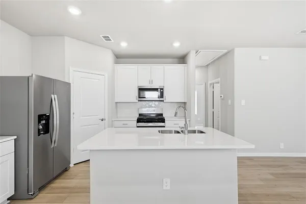 a kitchen with stainless steel appliances a refrigerator stove and microwave