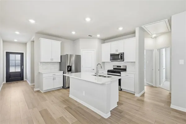 a kitchen with white cabinets and stainless steel appliances