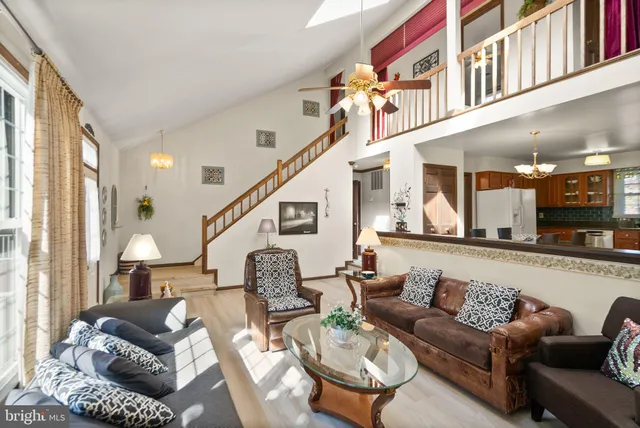 a kitchen with stainless steel appliances granite countertop a refrigerator a oven a sink and a dining table with wooden floor