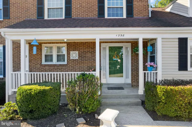 a view of a house with a yard and potted plants