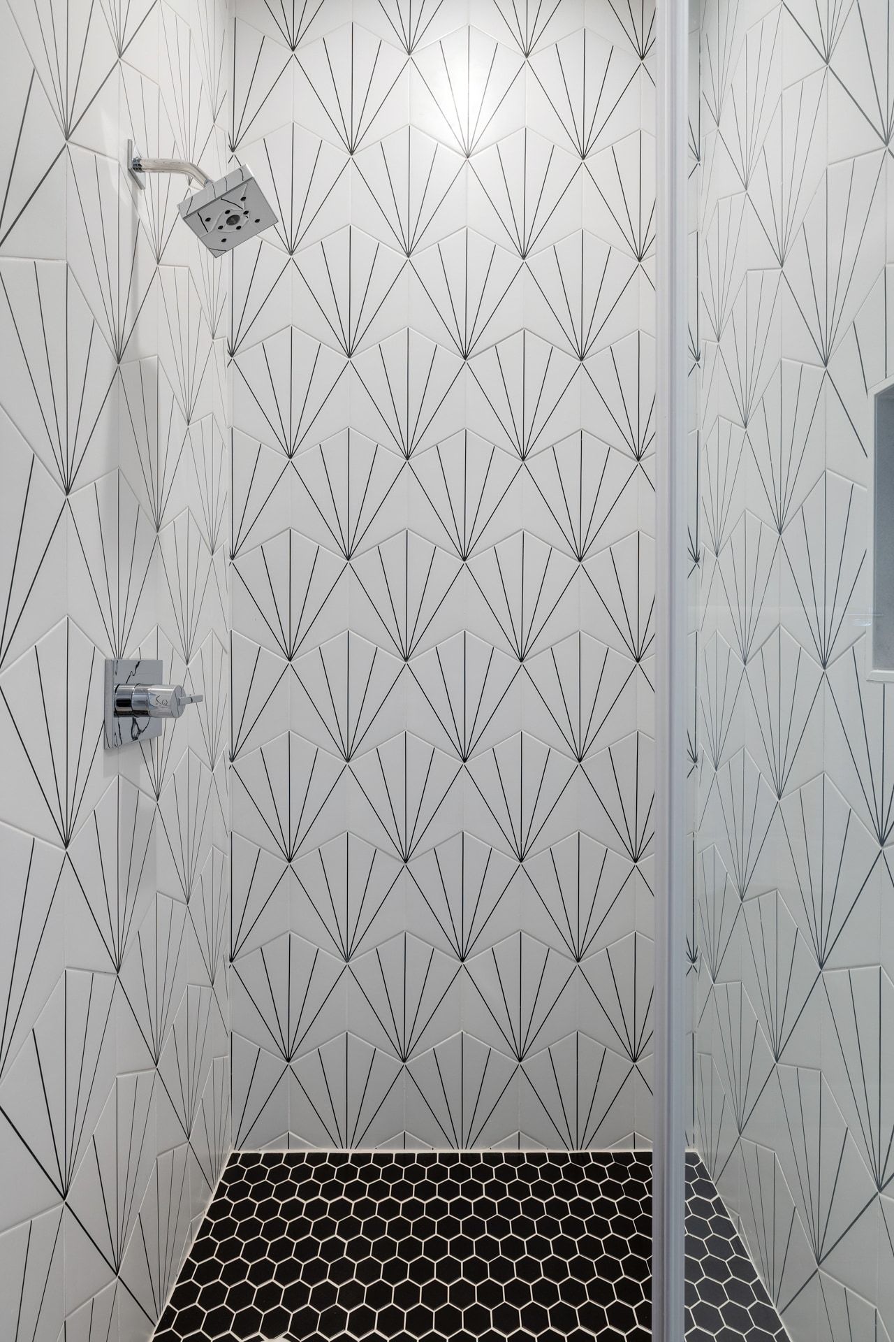 5405 Montview Street Austin, TX 78756 - Photo 25 of 40 Shower enclosure featuring geometric fan-patterned wall tiles, a square shower head, chrome fixtures, and black hexagonal floor tiles