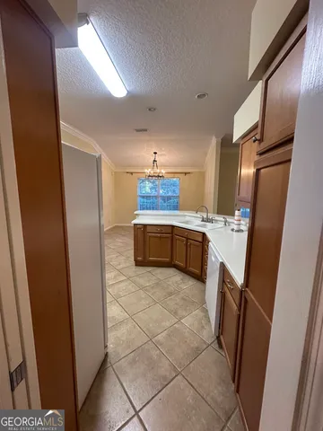a kitchen with granite countertop a refrigerator and a sink