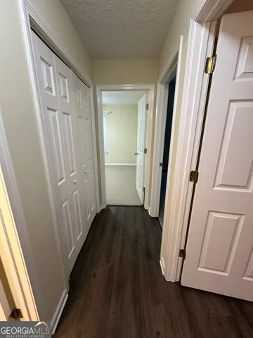 a view of a hallway with wooden floor and staircase