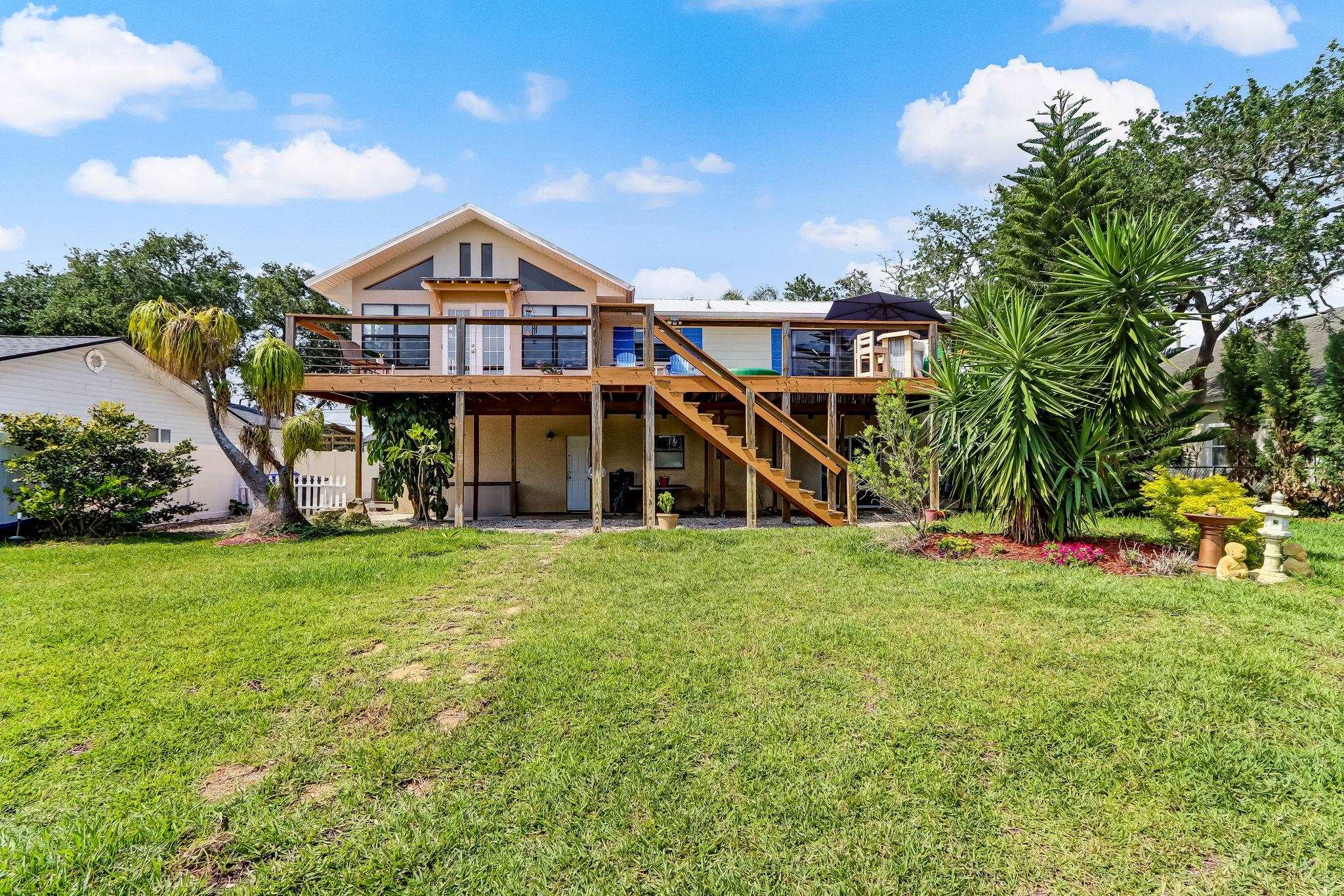 247 Treasure Beach Road St. Augustine, FL 32080 - Photo 25 of 28 a view of a big house with a big yard and large trees